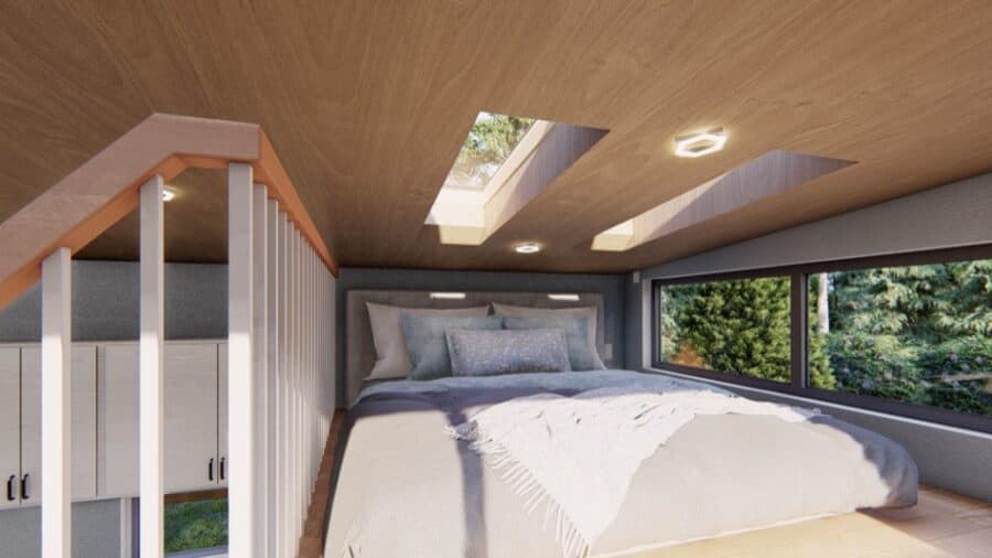 Cozy tiny house bedroom with skylights and large window overlooking nature.