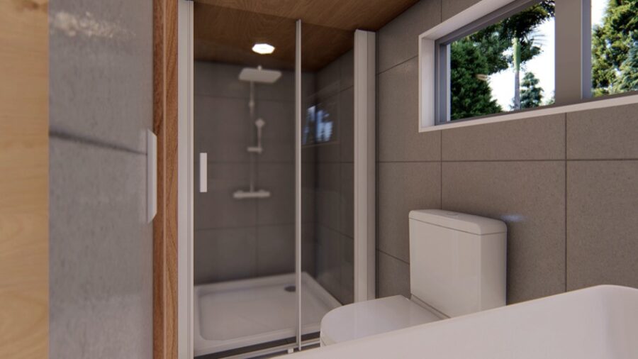Modern tiny house bathroom with shower, toilet, and large window for natural light.