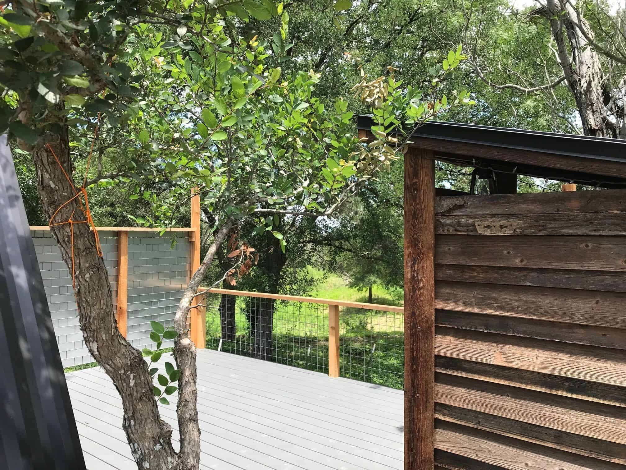 Outdoor shower area surrounded by trees on the deck at Spencer Ranch cabin