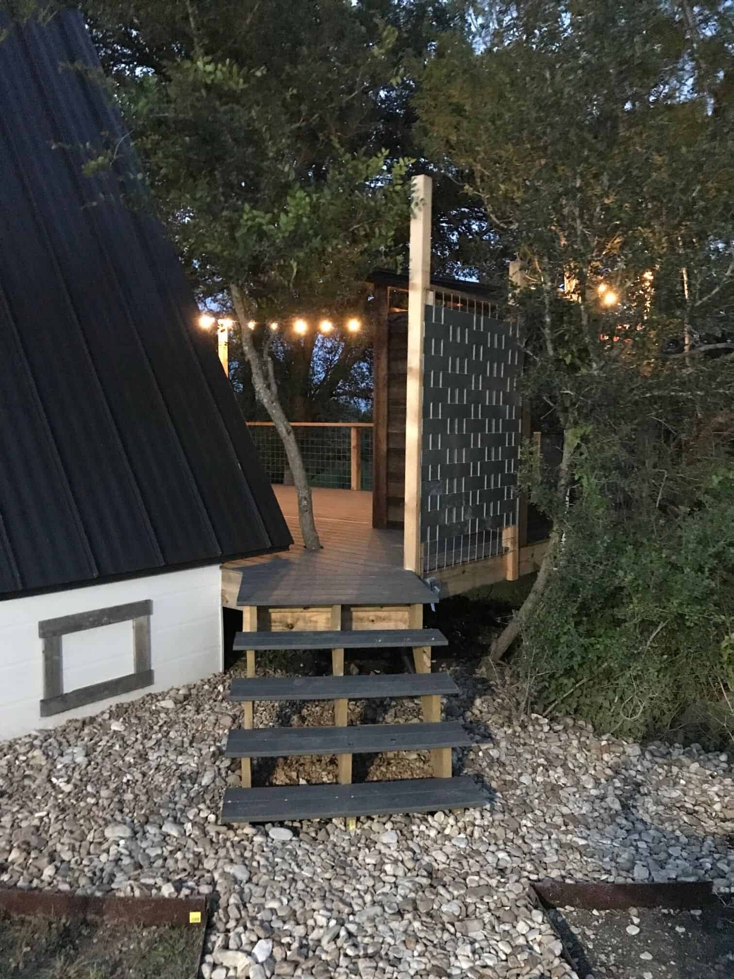 Deck steps at dusk with string lights at The Cabin at Spencer Ranch