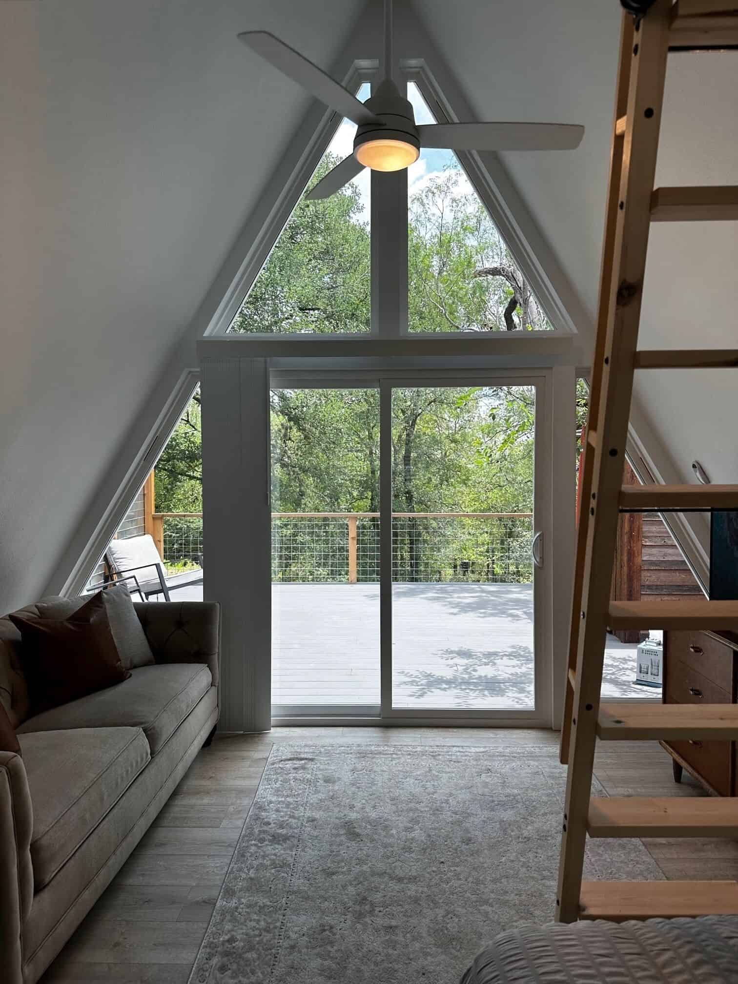 Looking through the A-frame glass wall and sliding doors to the wooded deck at Spencer Ranch