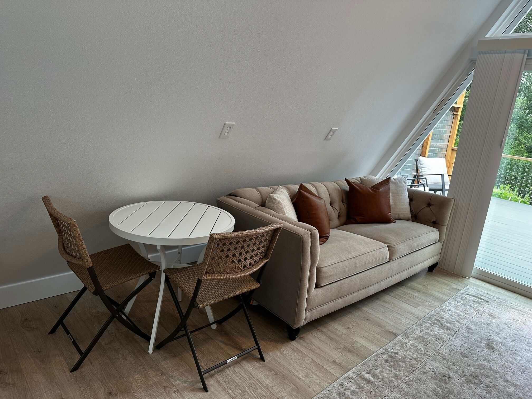 Spencer Ranch cabin living area with tufted couch, leather pillows, and bistro dining table