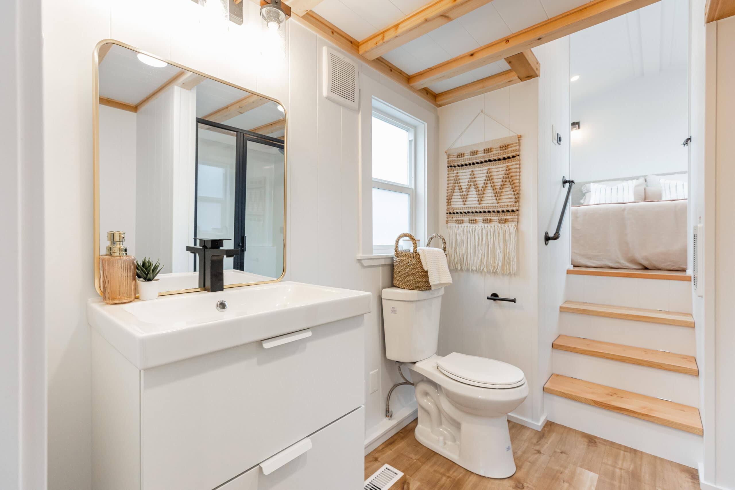 Small bathroom with white walls, wooden accents, and a compact vanity.