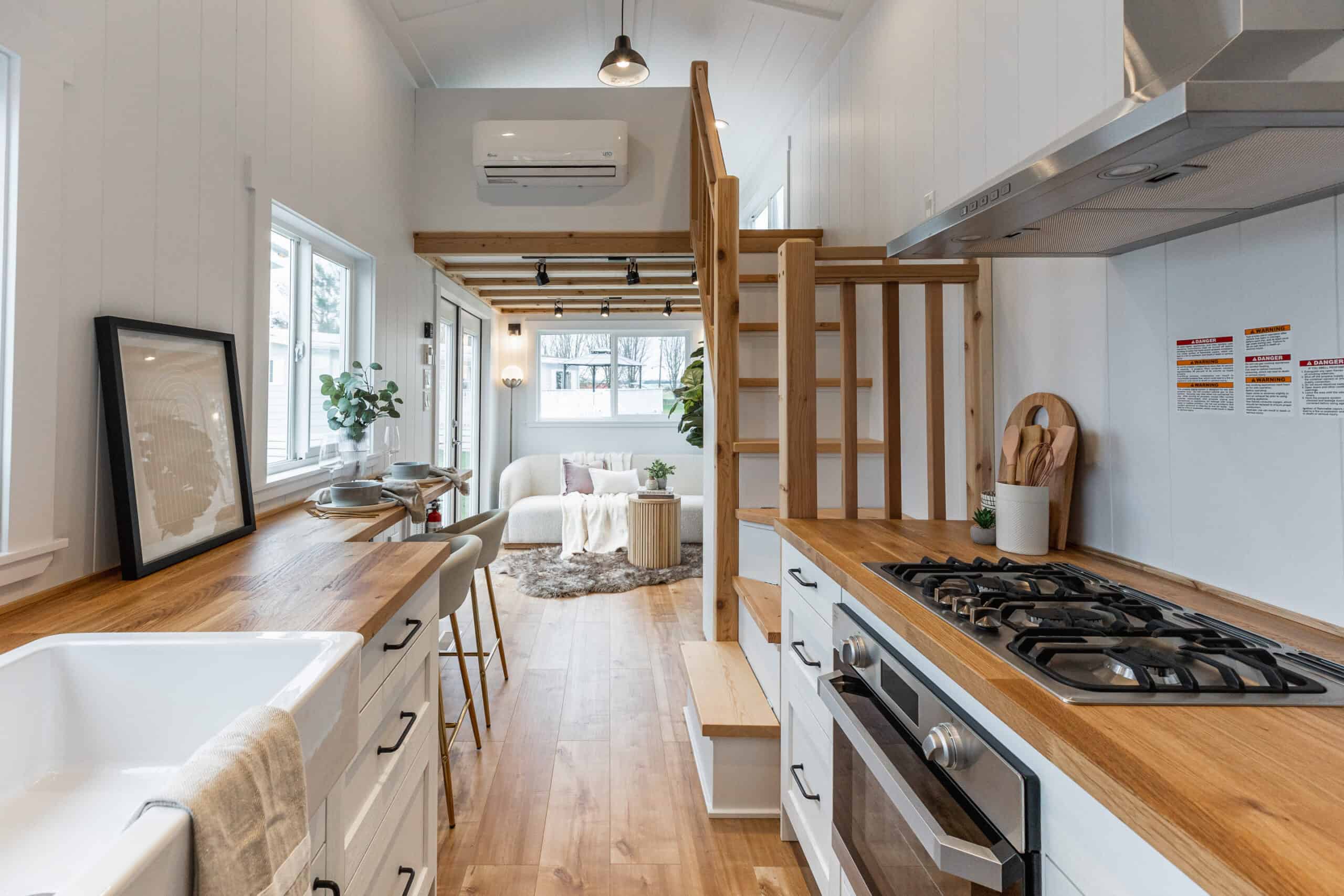 Bright tiny house kitchen with wooden accents and open living space.