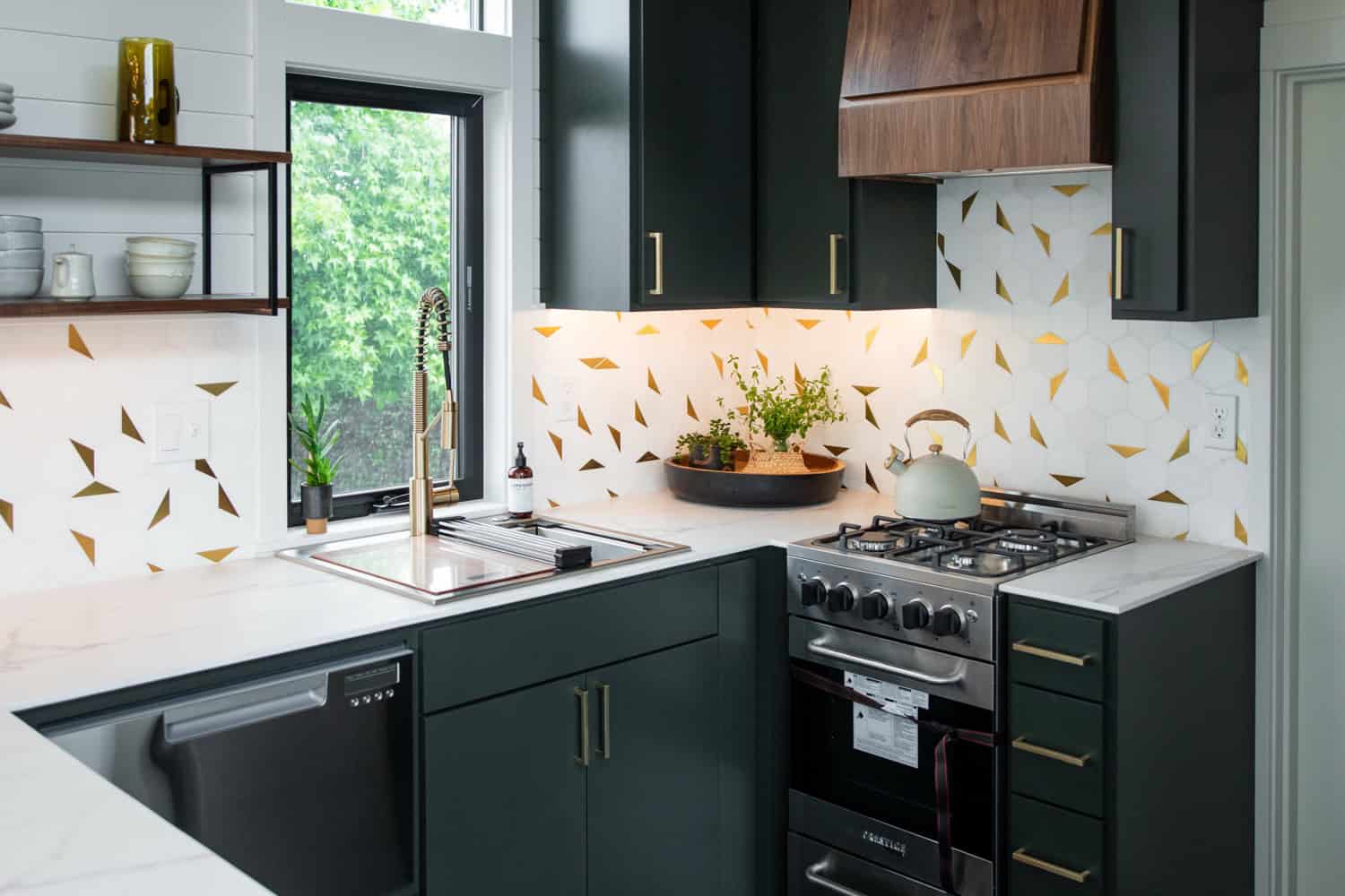 Cascade Max kitchen with dark green cabinets, gold-and-white hexagon backsplash, champagne hardware, and walnut range hood