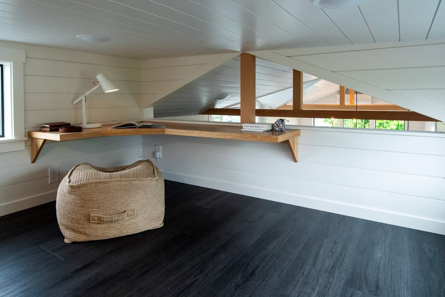 Loft with a floating live-edge wood workspace, bean bag, and dark plank floor in the Cascade Max