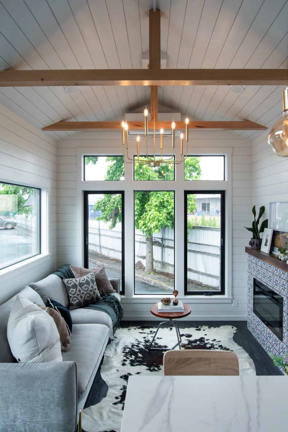 Vaulted white shiplap ceiling with exposed wood beams and a brass chandelier over the Cascade Max living room