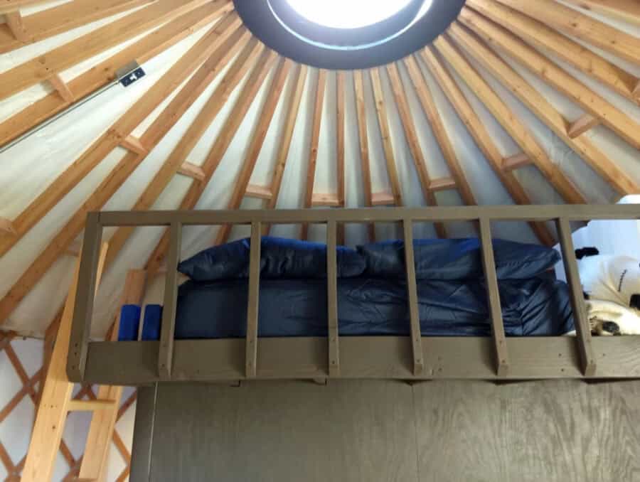 Compact tiny house loft with circular skylight.