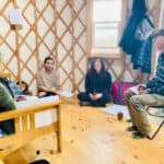 Group of people attending a tiny house workshop in a cozy wooden interior.