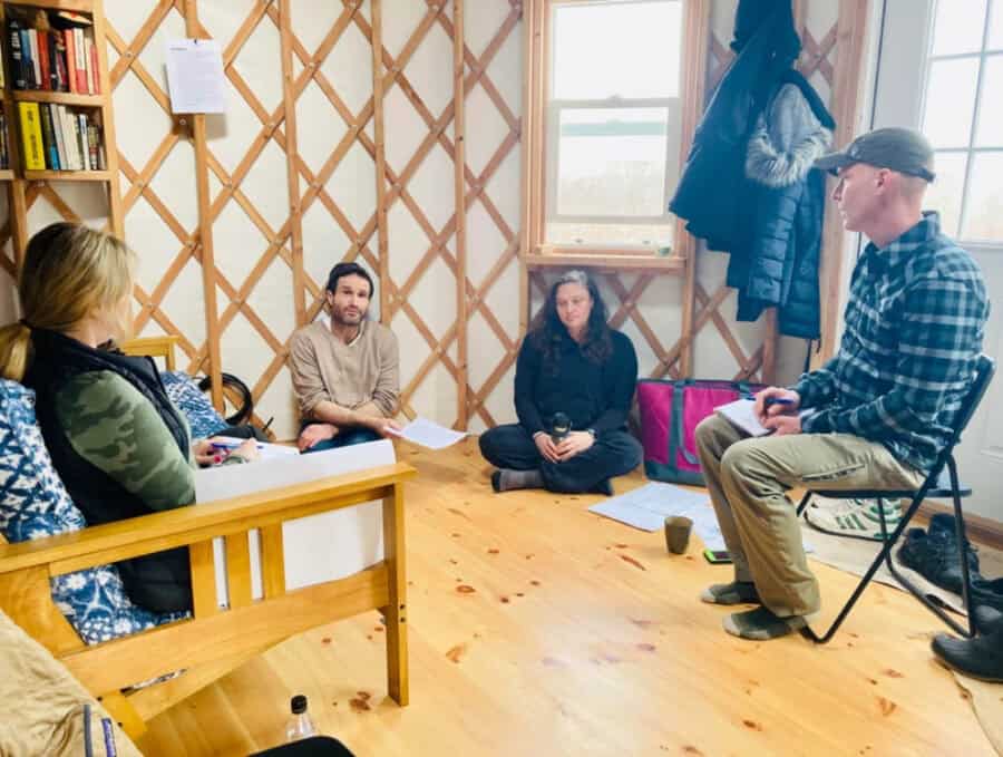 Group of people attending a tiny house workshop in a cozy wooden interior.