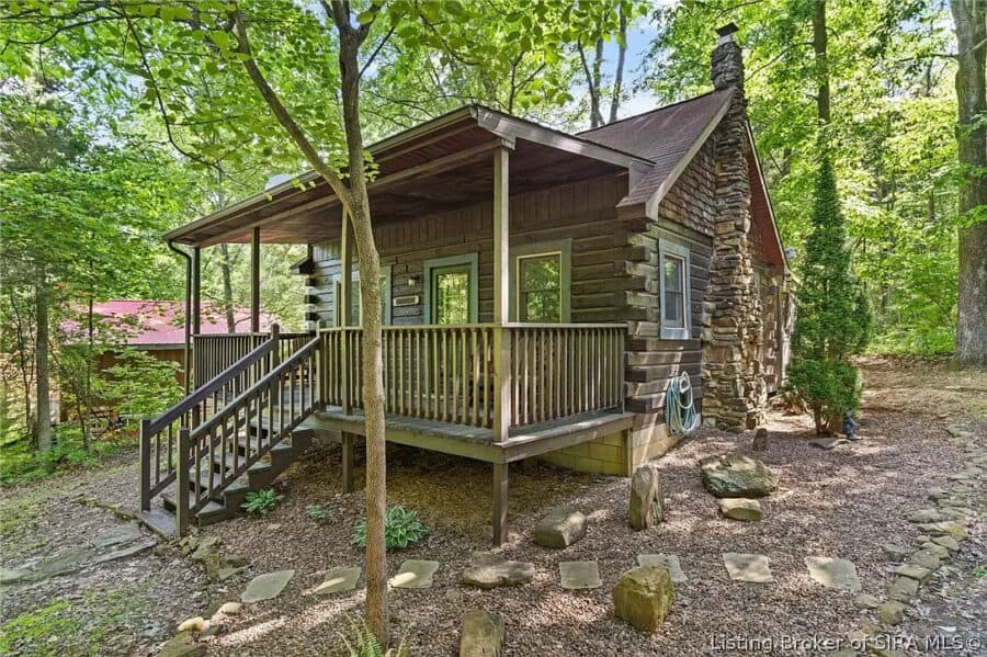 Cozy log cabin in Indiana surrounded by lush trees and nature.