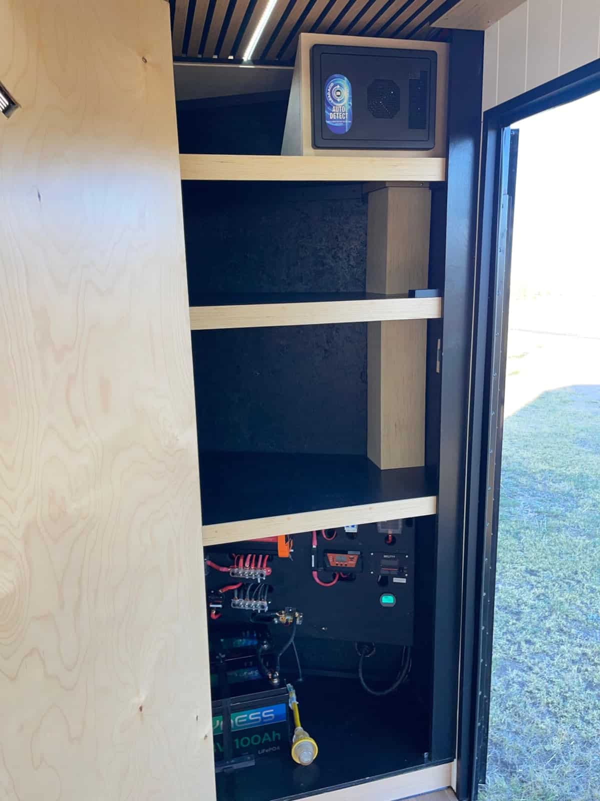 Tall storage cabinet with the battery bank and electrical components at the bottom