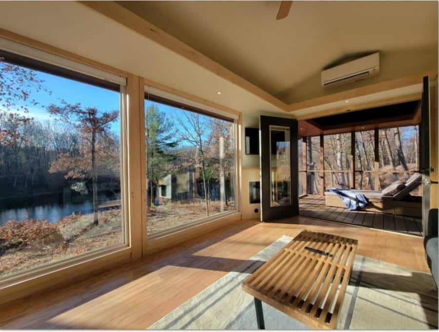 Bright, modern tiny house with large windows overlooking nature.
