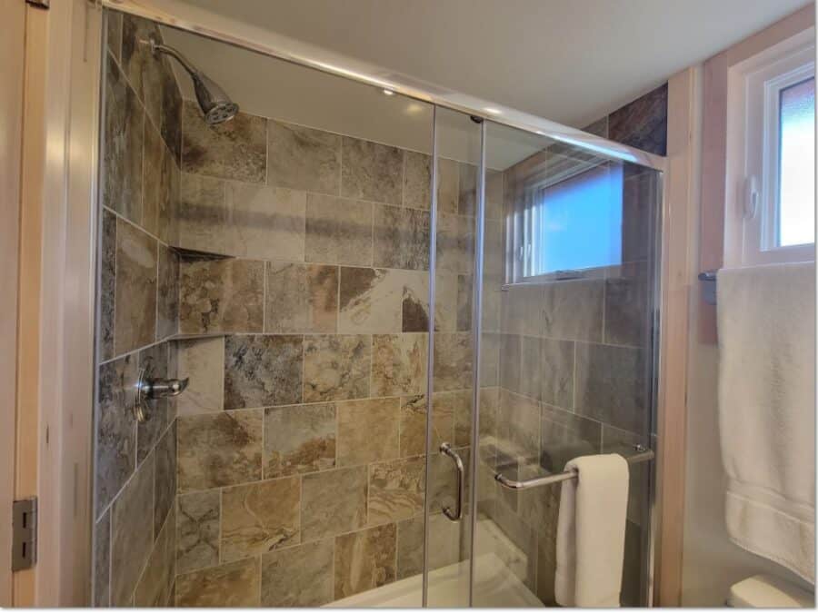 Compact rustic bathroom with stone tile shower and modern fixtures.