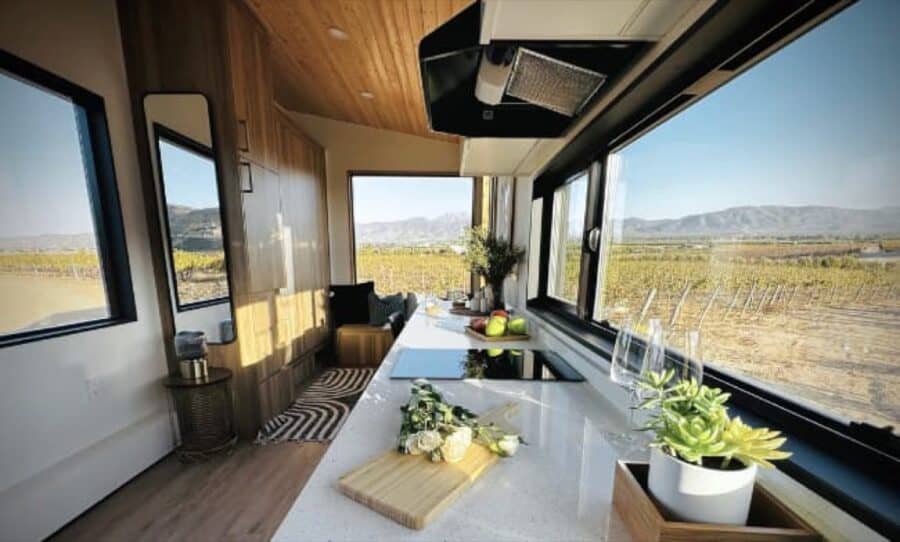 Bright tiny house interior with large windows and modern decor.