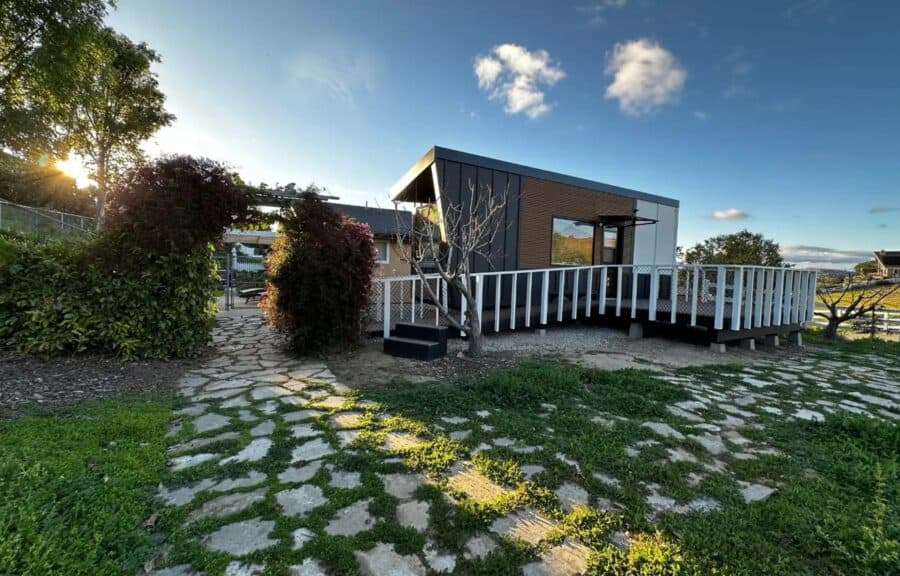 Compact tiny house with modern design and spacious deck, perfect for small space living.