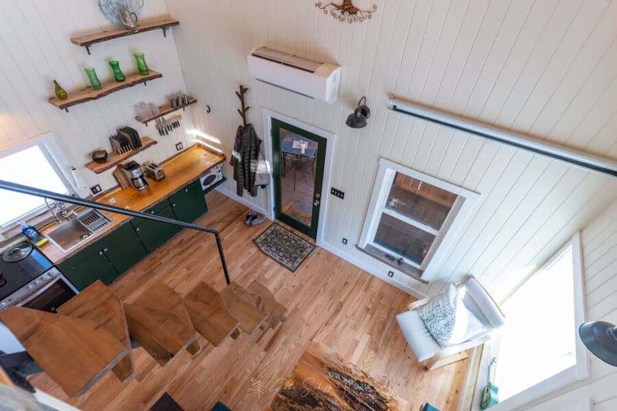 Bright tiny house interior with compact kitchen and cozy seating area.