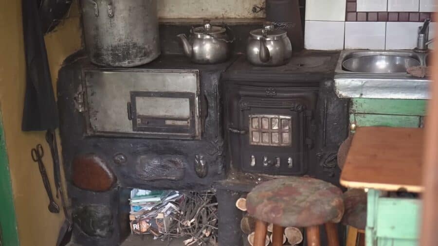 Wood cookstove on a cob base with a passive oven beside it