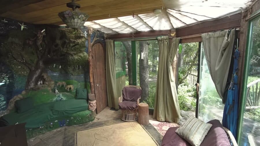 Covered porch enclosed with salvaged windows in the cob home