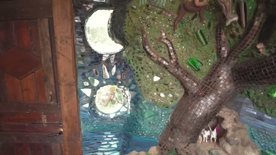 Sculpted cob tree covered in tile and glass mosaic in the living room