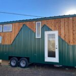 Tiny house on wheels with mountain-inspired siding and modern design.