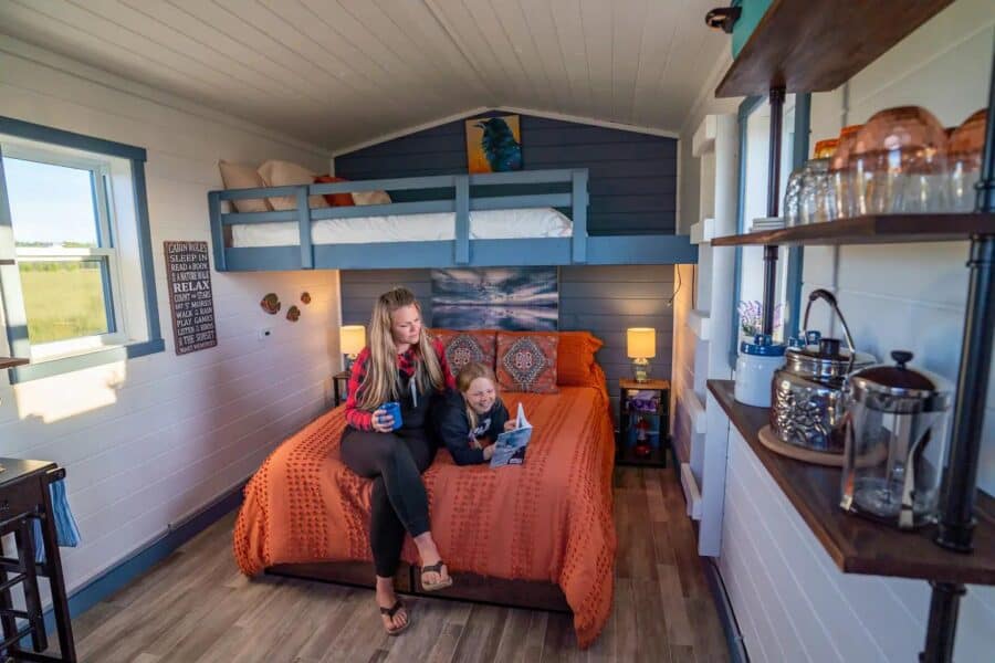 Charming tiny house interior with a loft, cozy bed, and bright decor in Nova Scotia. Perfect for sma.