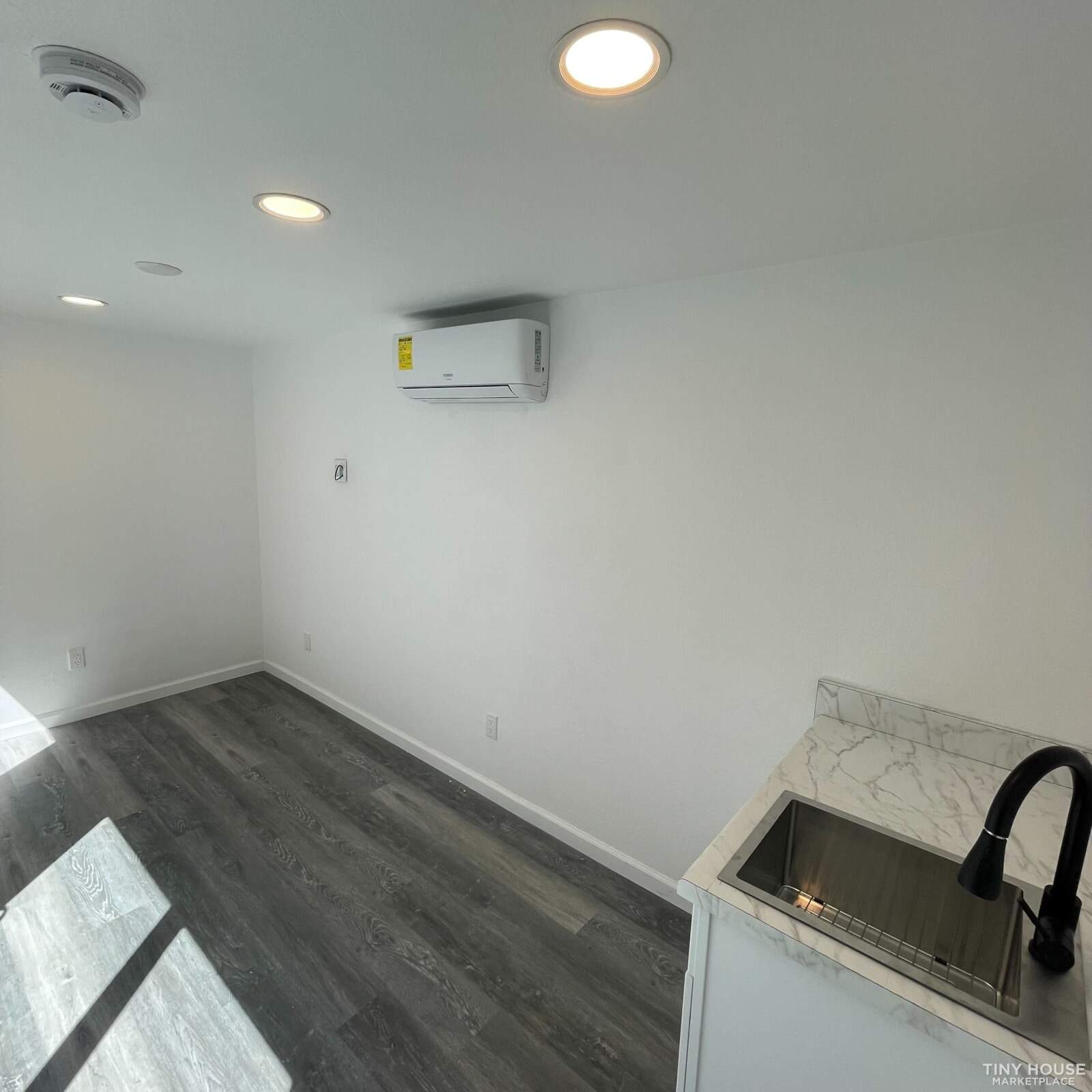 Kitchen area with base cabinet, sink, and refrigerator space