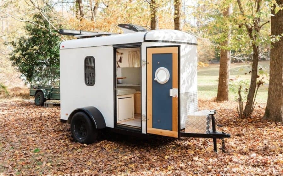 Compact tiny house trailer with cozy interior, perfect for small space living.