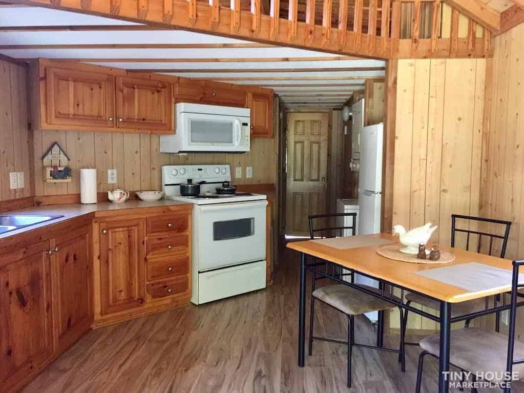 Kitchen and dining area of the Country Cottage furnished with a four-seat table during its time as a vacation rental.