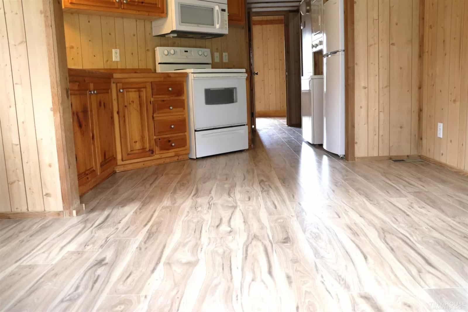 Kitchen of the Country Cottage unfurnished, showing the new plank flooring running down the hallway.