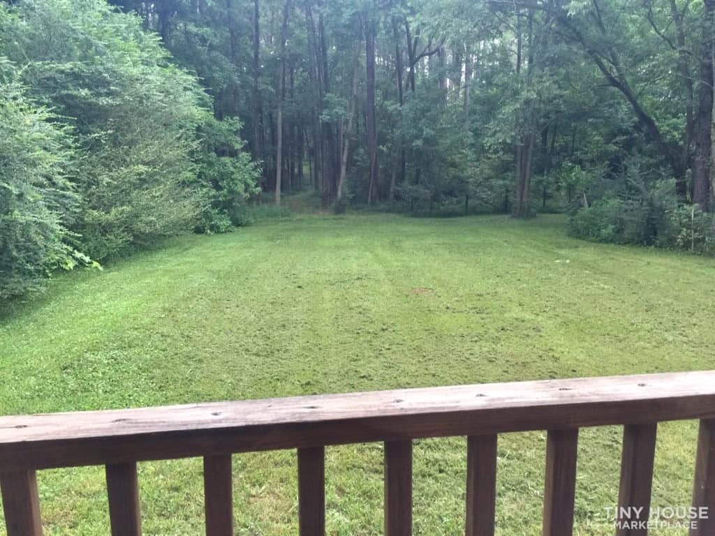 Green lawn and tree line seen from the deck railing of the Country Cottage in rural west Tennessee.