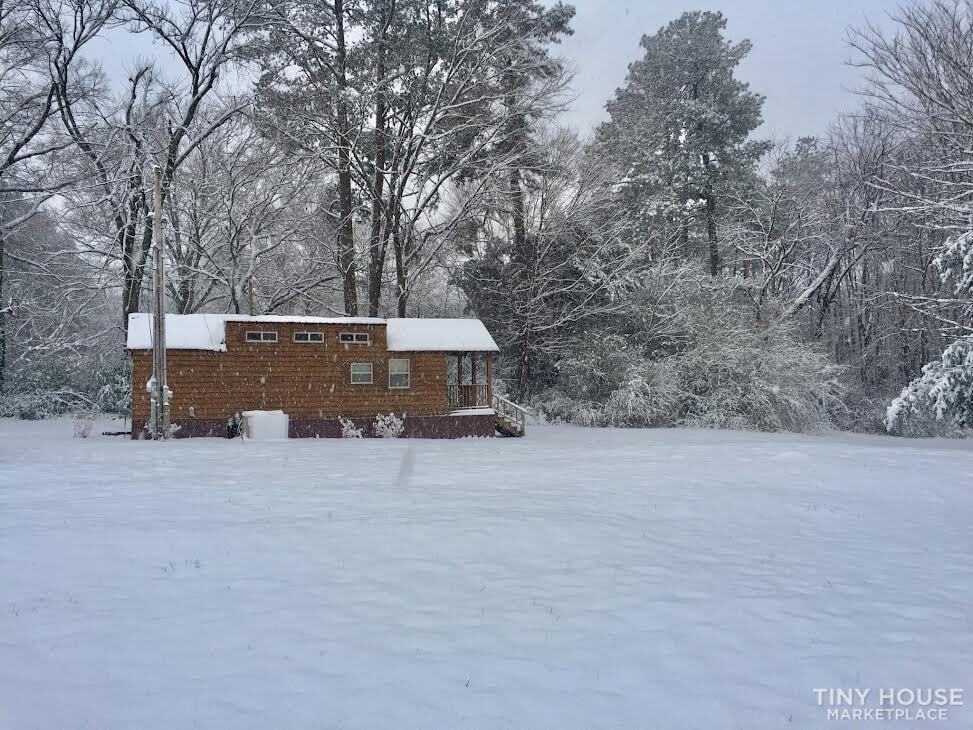 The Country Cottage tiny home surrounded by snow-covered trees during a west Tennessee winter.
