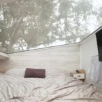 Small tiny house bedroom featuring a large skylight and compact design.