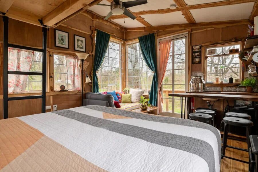 Charming four-season tree house in West Virginia with warm wooden decor and large windows.