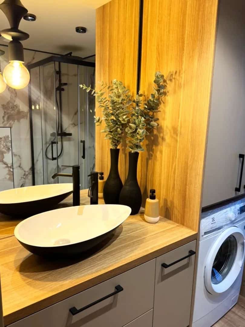 Wood vanity with black vessel sink and a washing machine in the Jake modular house bathroom