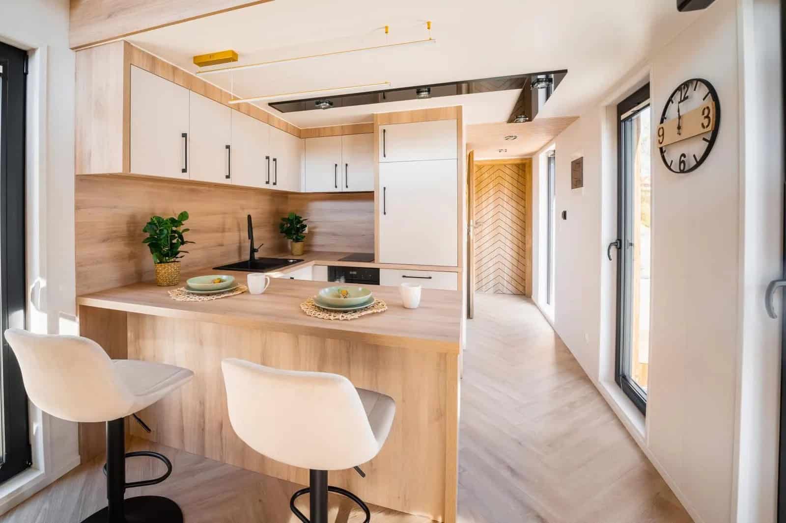 Lukas kitchen island with bar stools looking down the open-plan interior toward the bedroom and bathroom