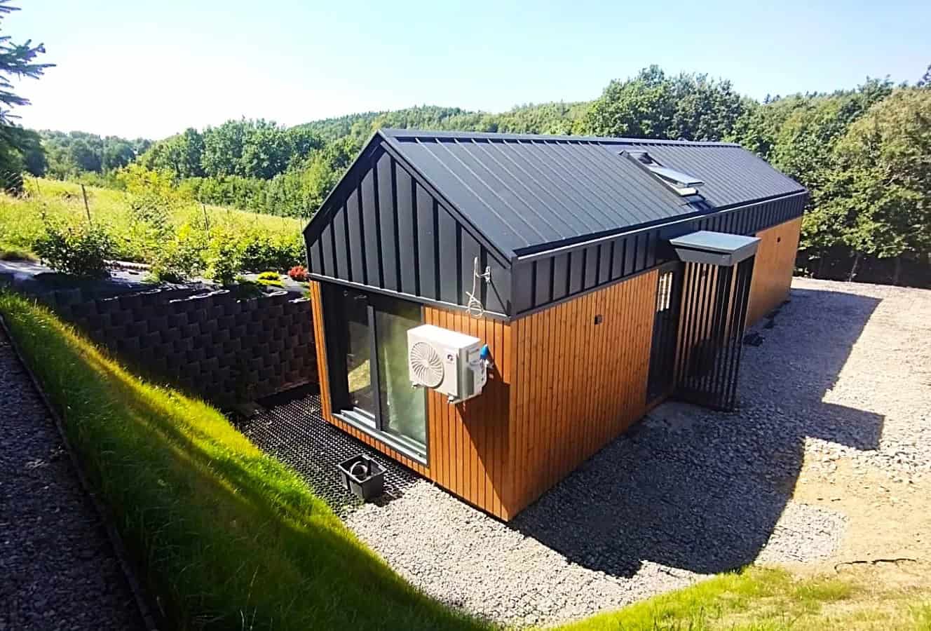 Lukas modular house by Craft House with a charcoal gable roof and thermo-pine wood cladding in a green rural setting