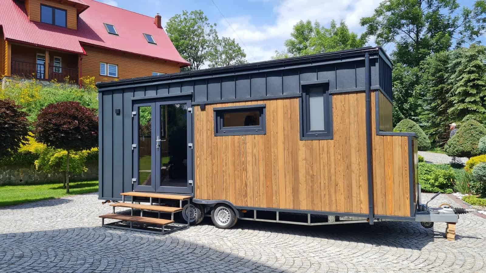 Side view of the Off-Grid Craft House showing thermo-pine wood cladding and twin-axle trailer