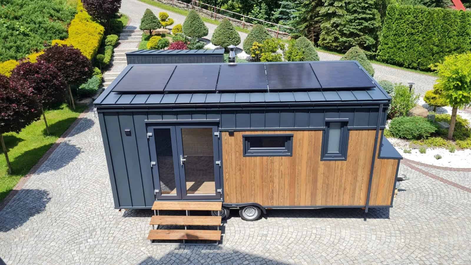 Off-Grid Craft House tiny house with rooftop solar panels and two-tone charcoal and wood exterior