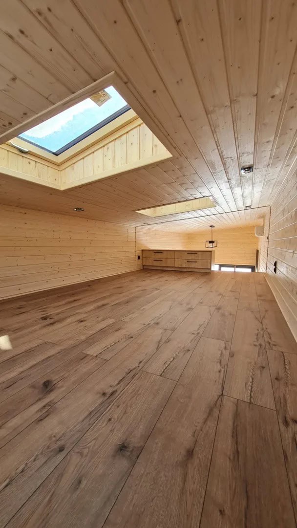 Spacious skylit mezzanine in the Samuel modular house finished in spruce with a roof window