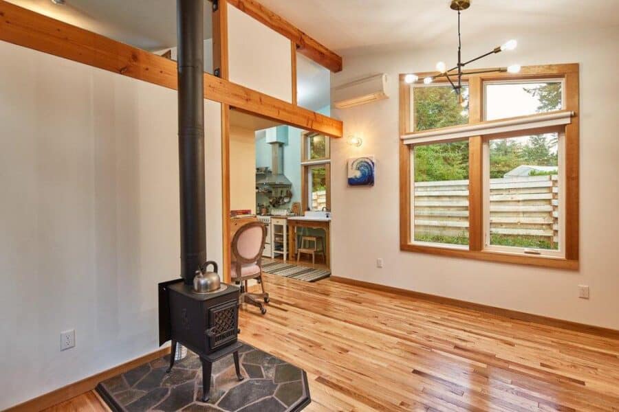 Bright and airy tiny house living space with large windows and natural wood accents.