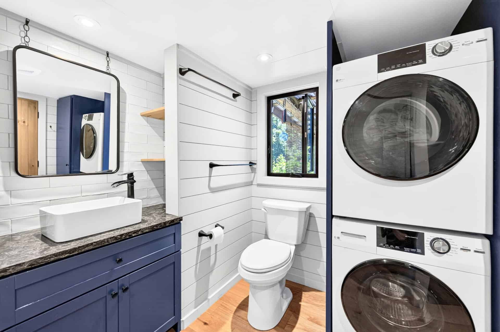 Bathroom vanity with vessel sink beside a stacked washer and dryer