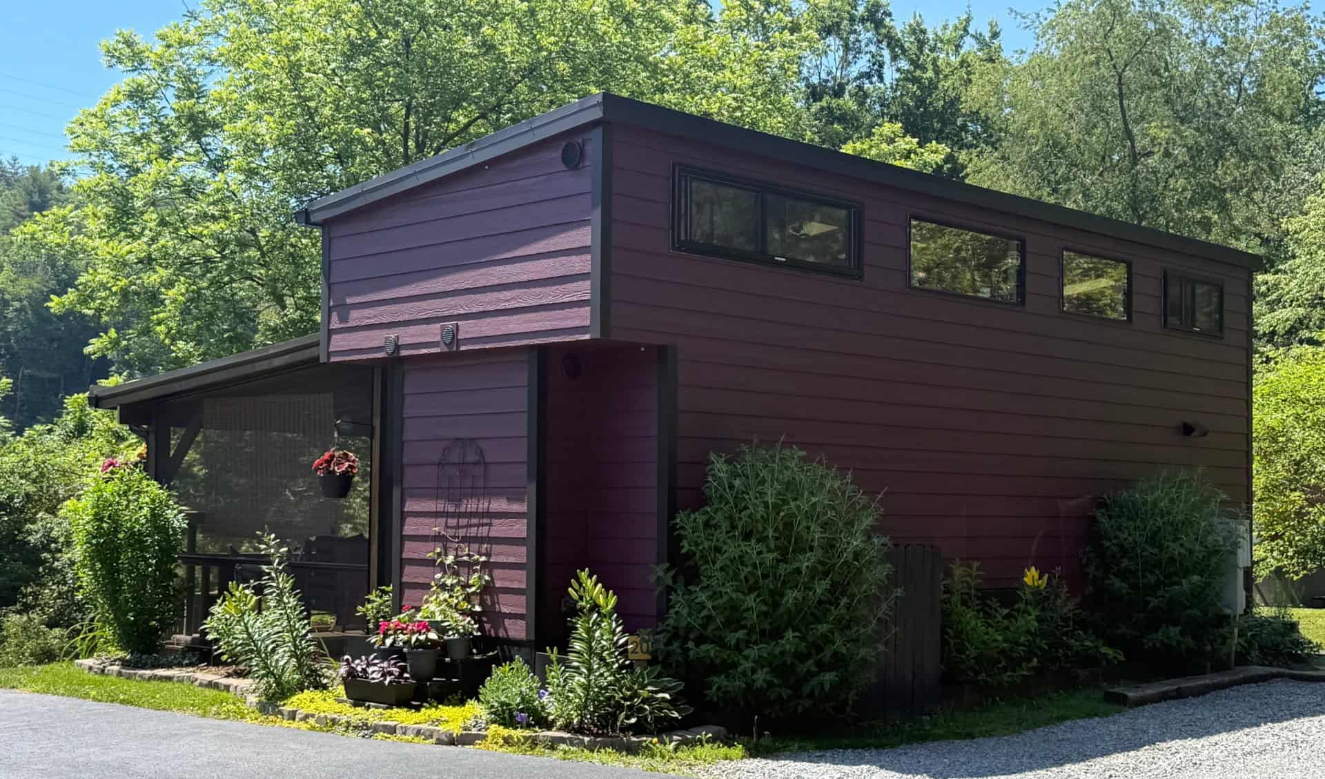 Deep plum modern tiny house with shed roof and screened porch in the Acony Bell community