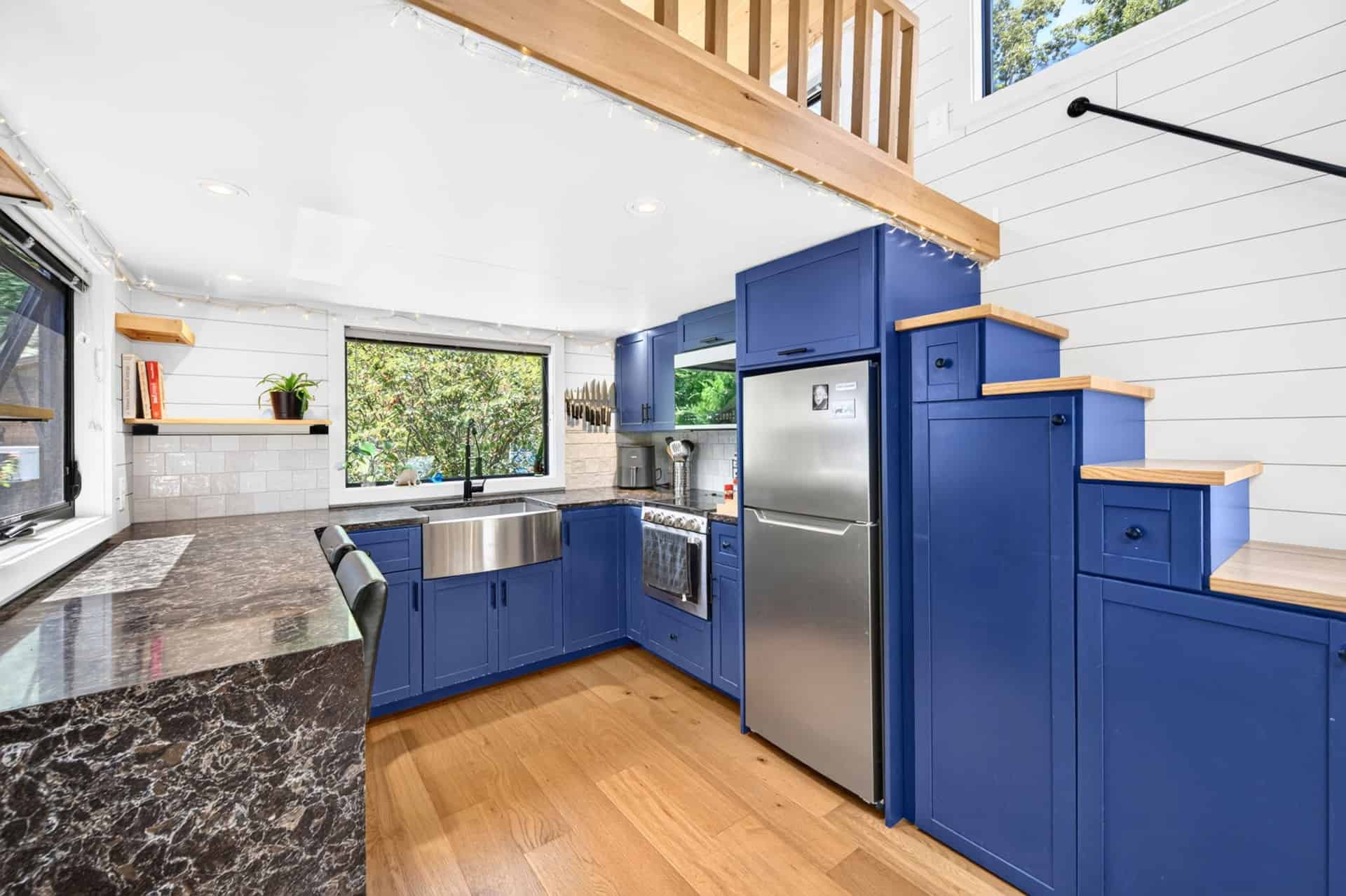 Navy storage staircase leading to the loft with built-in drawers and cabinets