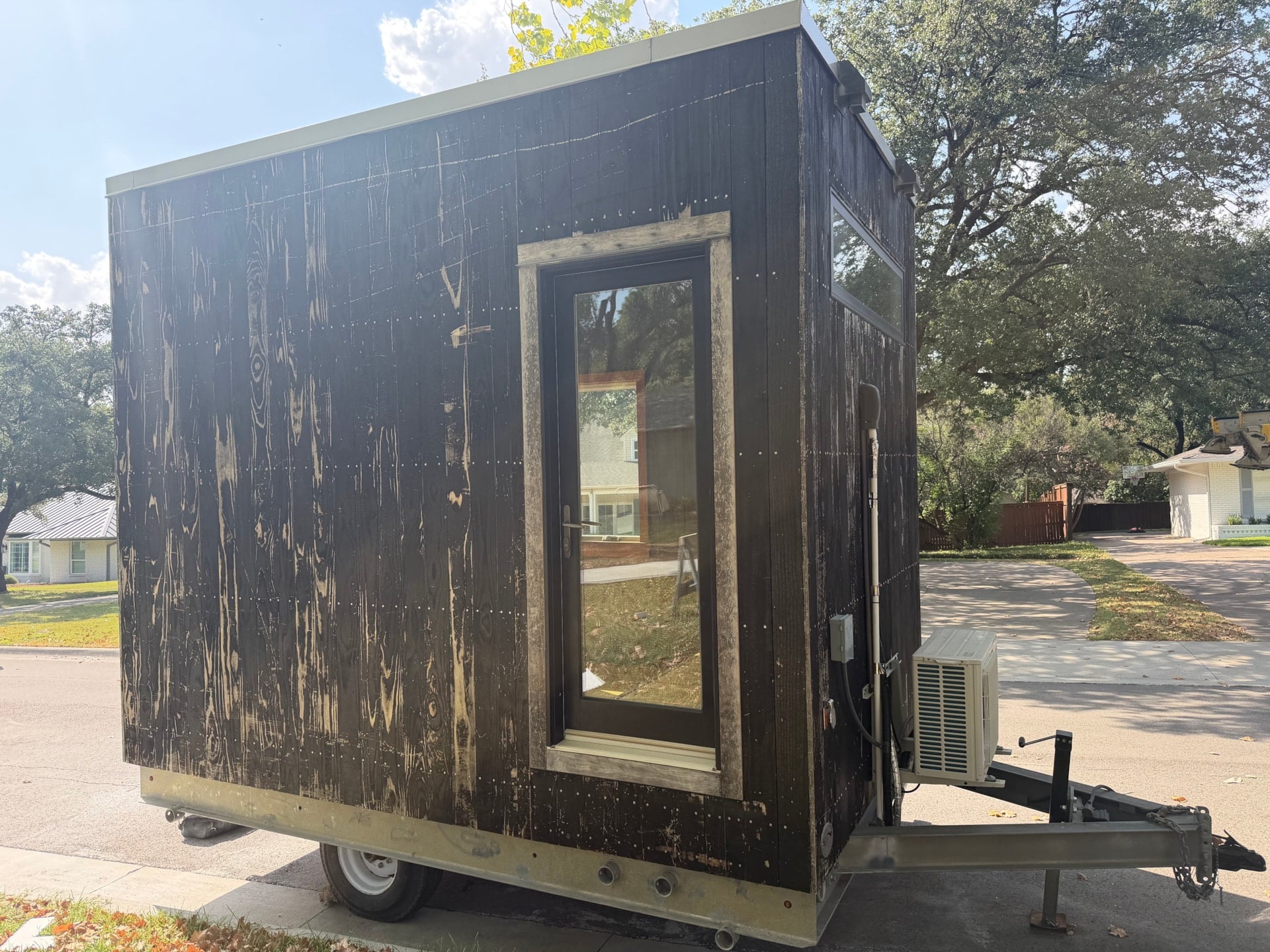 Door side exterior view of the Adirondack tiny house for sale in Dallas Texas