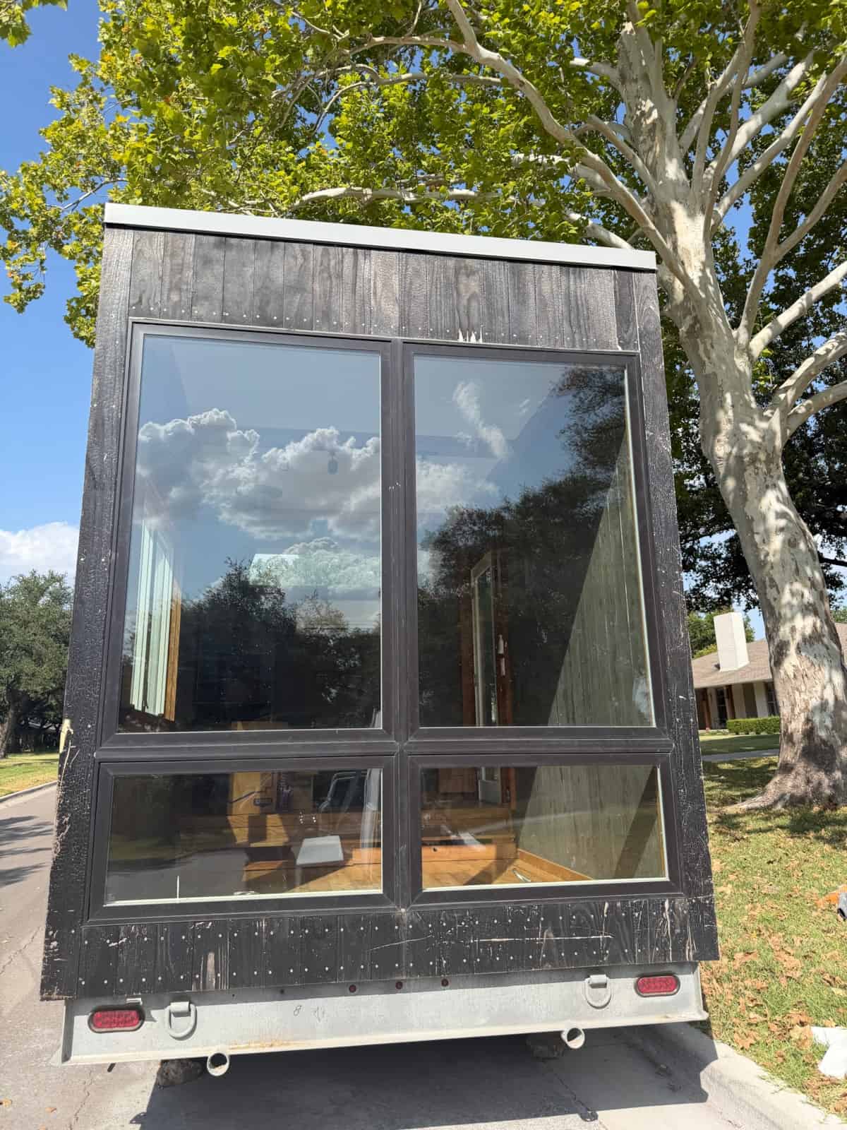 The large picture window wall of the Cubist Adirondack tiny house viewed from outside