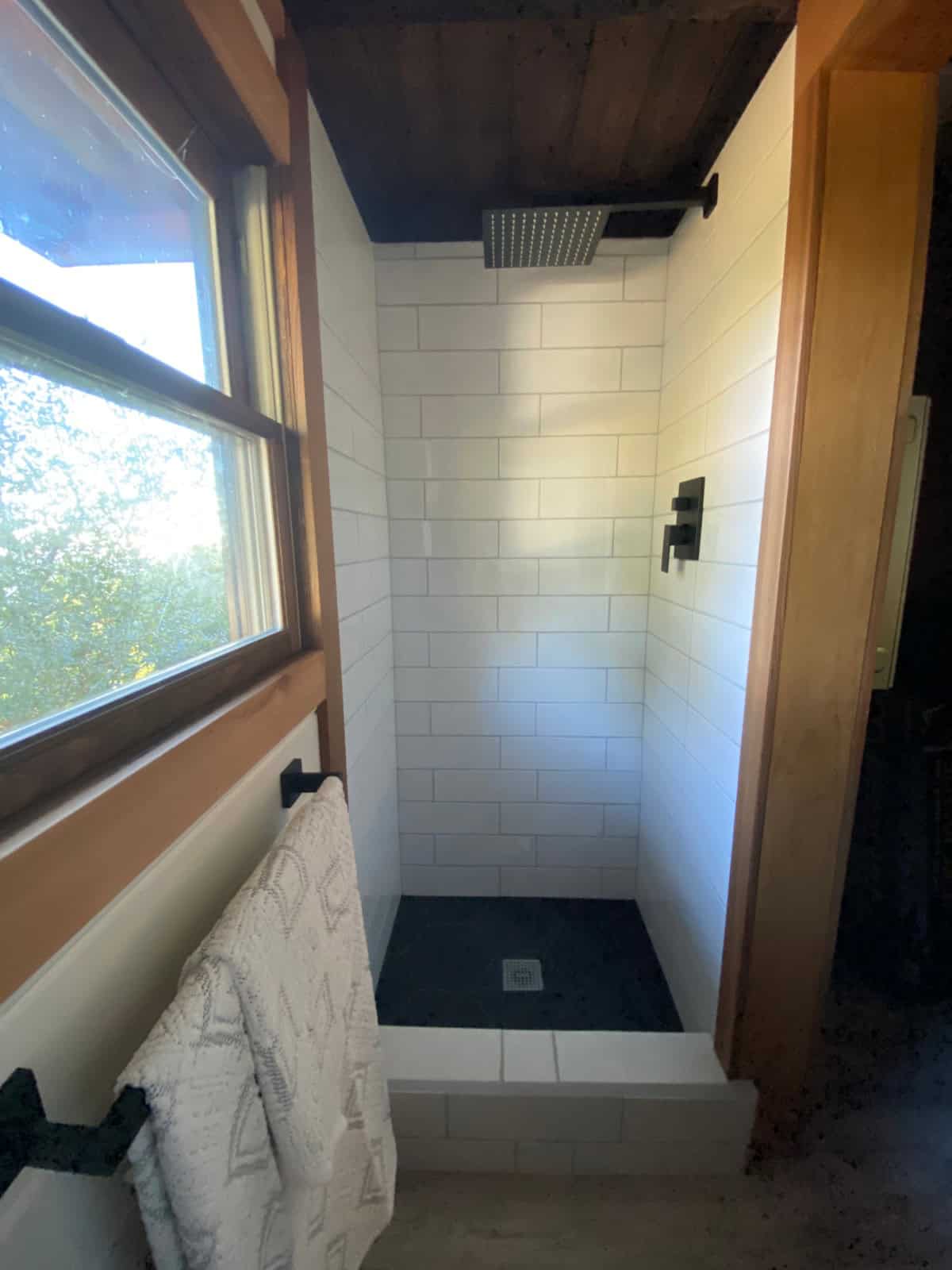 Tiled bathroom with ceiling-mounted rain shower head, white subway tile and slate floor