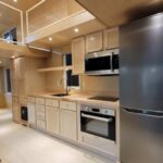 Modern tiny house kitchen with upgraded entertainment center and sleek appliances.