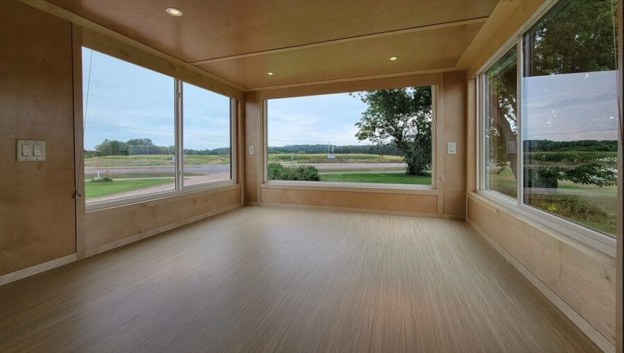 Interior view of a custom eONE tiny house featuring large windows and upgraded entertainment setup.