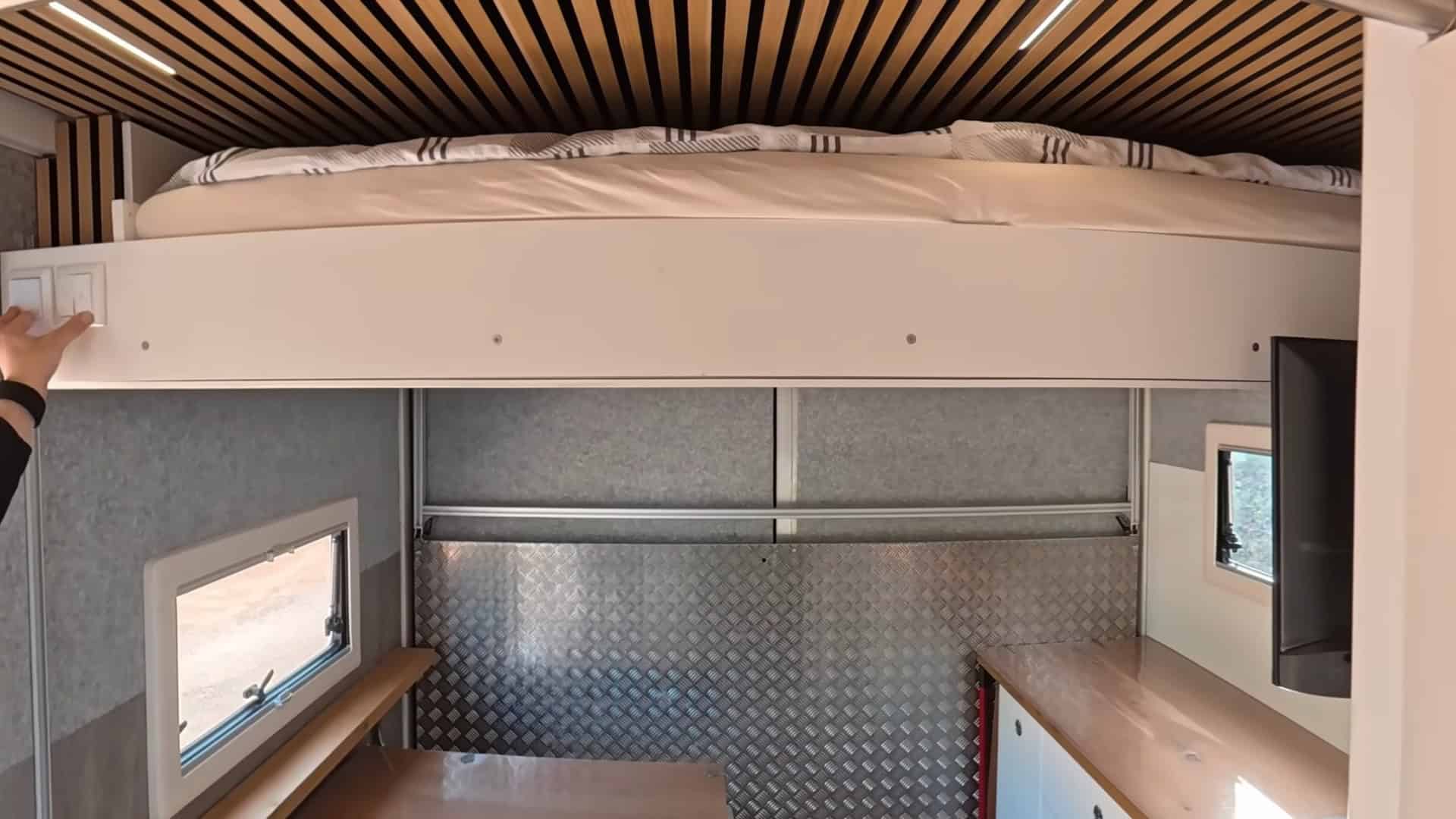 Elevator bed raised to ceiling showing the full living space, dining area, and kitchen below